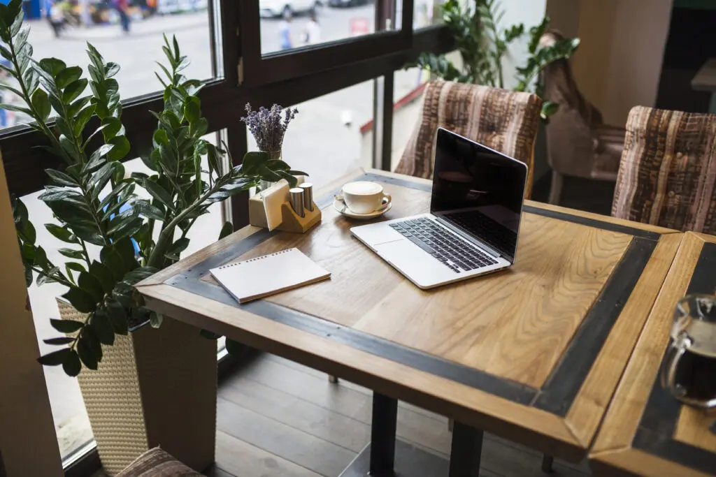 laptop with notepad cafe table (1)